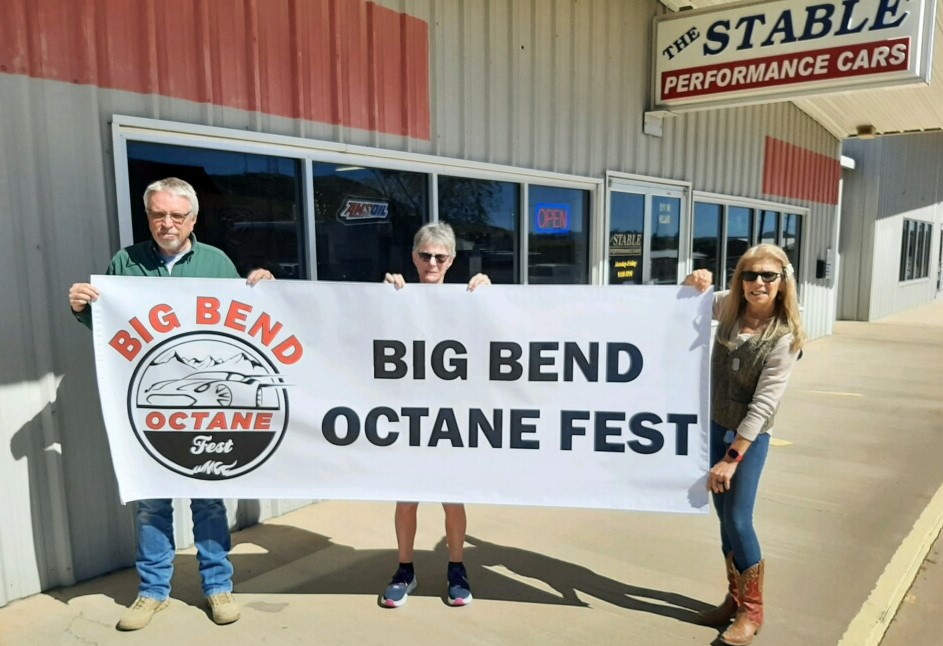 Three people holding up the 2022 banner for Octane Fest at The Stable Performance Cars in Alpine TX