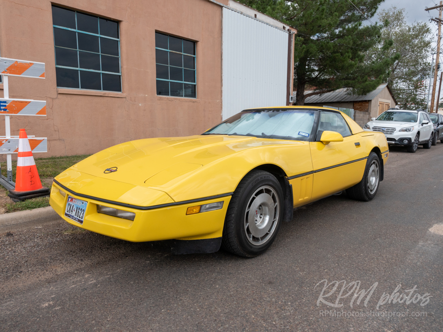 A yellow Corvette convertible parked at The Stable Performance Cars during Octane Fest.