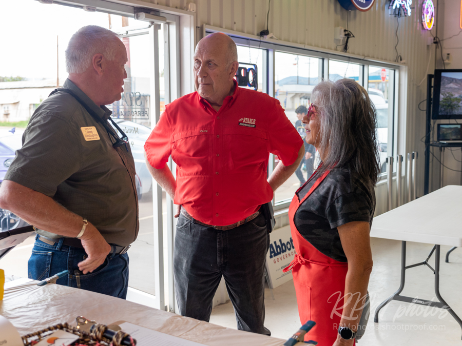 Owner Dave Durant visits with candidate for Brewster County Judge, Greg Henington, and Brewster County Republican Women Chairwoman, Monica McBride, at The Stable Performance Cars during Octane Fest.