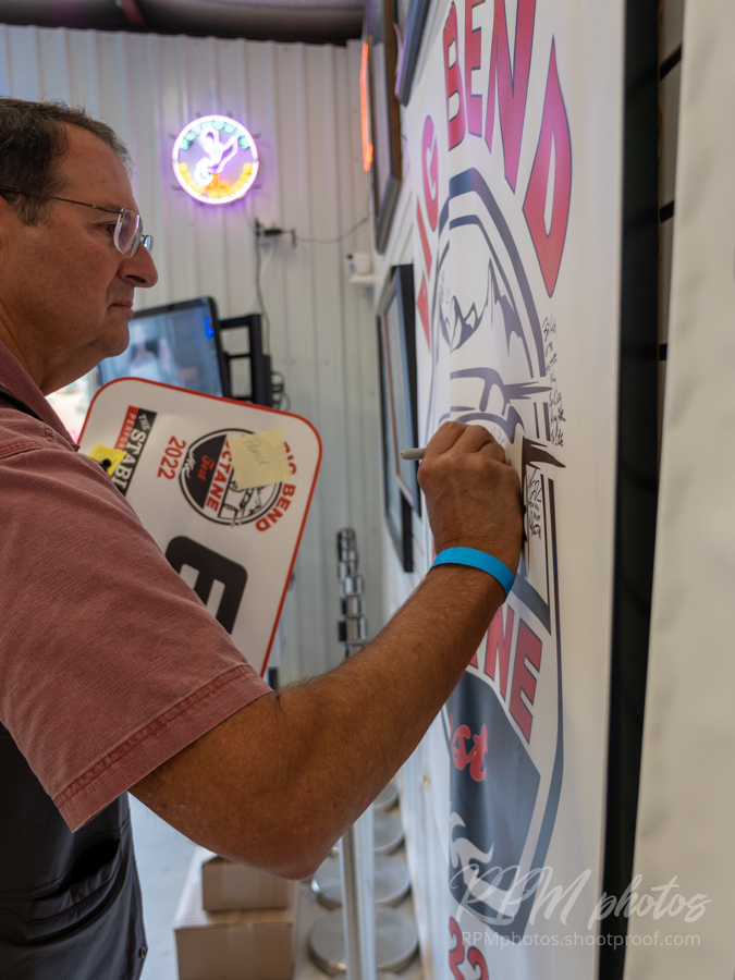 A man signs the Octane Fest Banner during the Law Enforcement Appreciation Dinner at The Stable Performance Cars during Octane Fest.