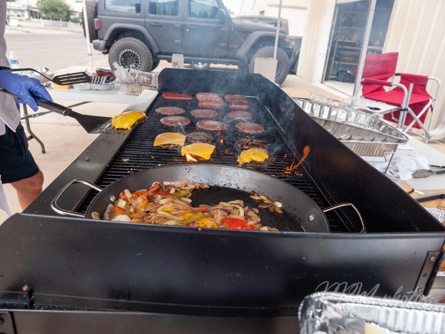 Hamburgers and fajitas on the grill at The Stable Performance Cars during Octane Fest .