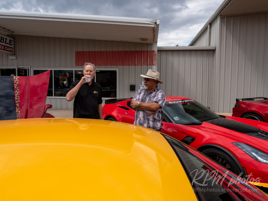 Two men drink water and talk at The Stable Performance Cars during Octane Fest.