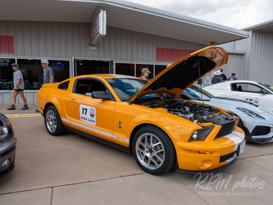 An orange Mustang is shown at the car show at The Stable Performance Cars during Octane Fest.