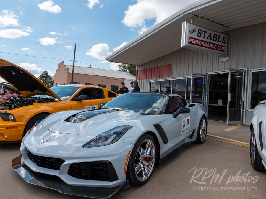 A gray Corvette and orange Mustang are shown at the car show at The Stable Performance Cars during Octane Fest.