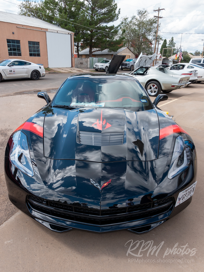 A black Corvette with red decals is shown at the car show at The Stable Performance Cars during Octane Fest.