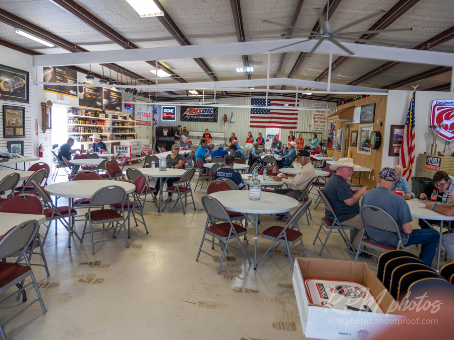 People sit at tables and enjoy visiting during Octane Fest at The Stable Performance Cars.