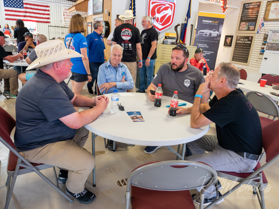 People sit at a table and enjoy visiting during Octane Fest at The Stable Performance Cars.