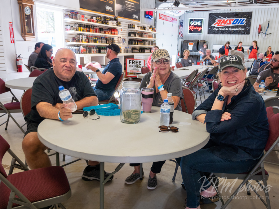 People sit at a table and enjoy visiting during Octane Fest at The Stable Performance Cars.