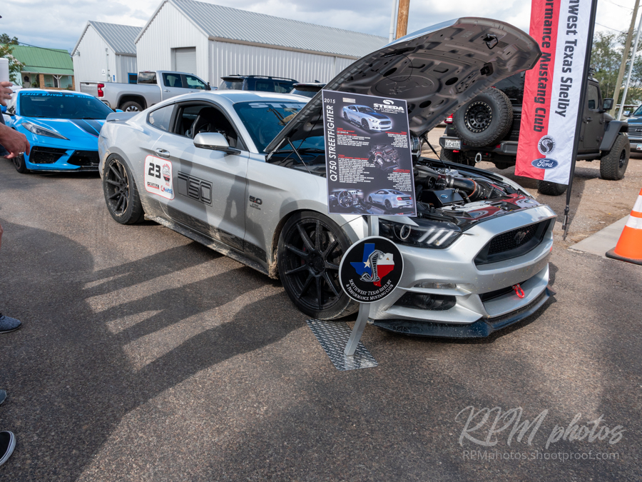 A gray 5.0 Mustang performance car is parked in the street during a car show at The Stable Performance Cars during Octane Fest.