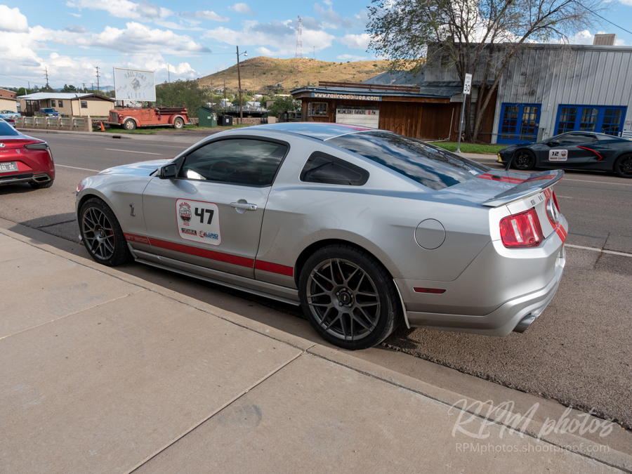 A gray Mustang Cobra parked in the street in front of The Stable Performance Cars during Octane Fest
